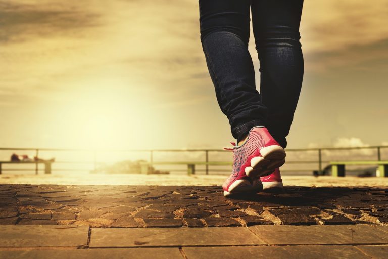Pessoa caminhando ao ar livre praticando exercício recomendado para quem tem varizes